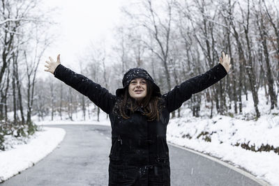 Close-up of woman standing on road amidst snow