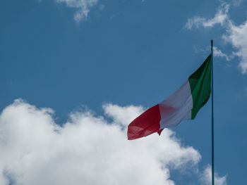 Low angle view of flags against blue sky