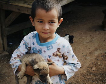 Portrait of cute boy playing with dog