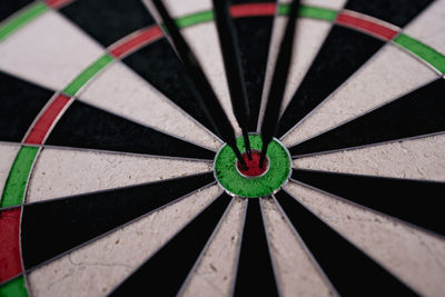 Three dart arrows hitting bullseye