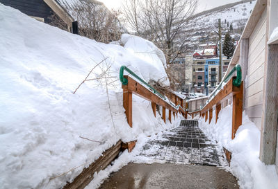 Snow covered street amidst buildings during winter