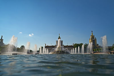 Water jets of the fountain against blue sky