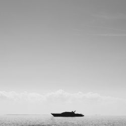 Ship sailing in calm sea against sky