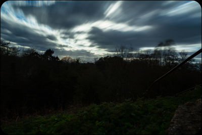 Silhouette trees on landscape against sky