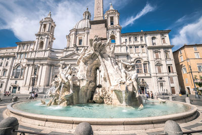 Statue of fountain in city against sky