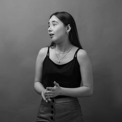 Young woman looking away against white background