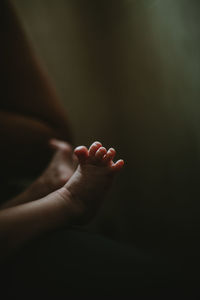 Low section of newborn baby lying on bed at home