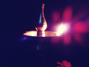 Close-up of lit candle in the dark