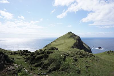 Idyllic shot of mountain and sea against sky