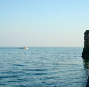 Boat sailing in sea against clear sky
