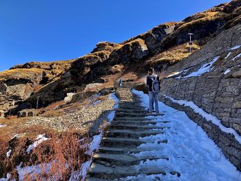 Man on snowcapped mountain against clear blue sky