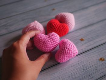 Cropped hand of woman holding heart shape on table