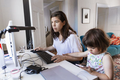 Mother and daughter sitting at desk together