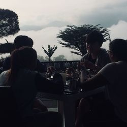 People sitting at restaurant against sky