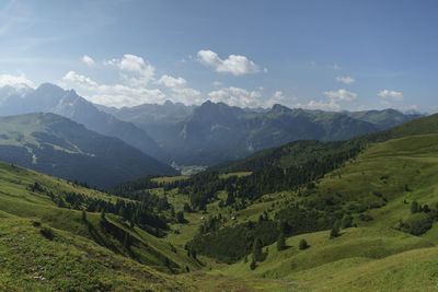 Scenic view of valley and mountains against sky