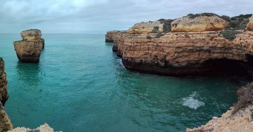 Rock formation in sea against sky