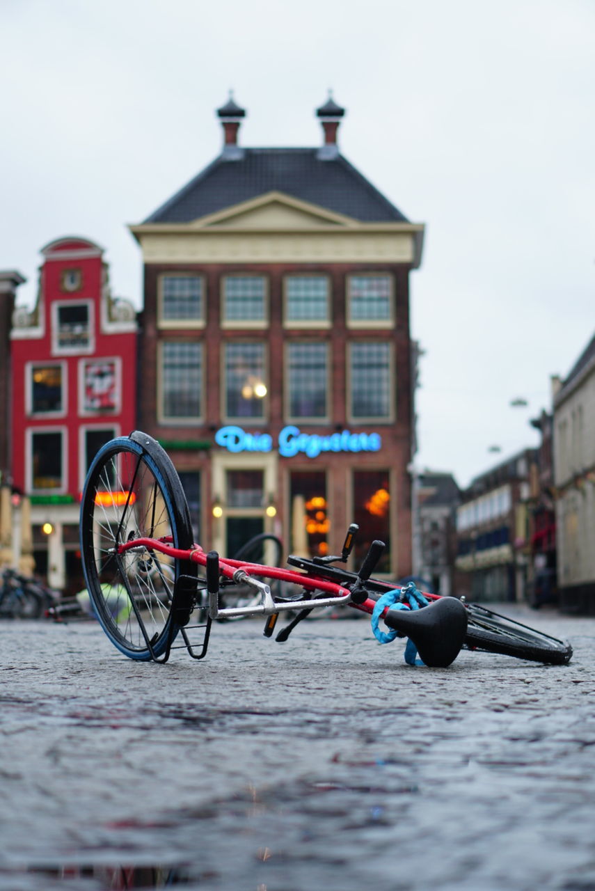 building exterior, built structure, architecture, transportation, land vehicle, bicycle, mode of transportation, city, building, nature, focus on foreground, outdoors, sky, day, no people, water, street, selective focus, lighting equipment, wheel