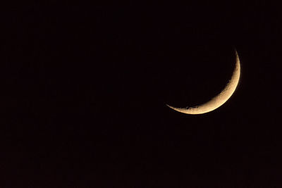 Low angle view of half moon against clear sky at night