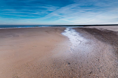 Scenic view of beach against blue sky