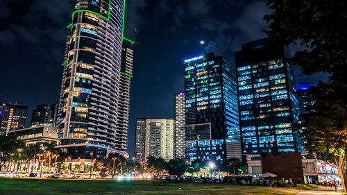 Low angle view of illuminated buildings against sky at night