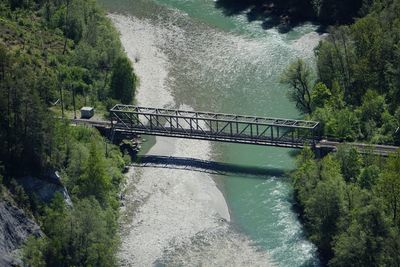 Bridge over river against trees