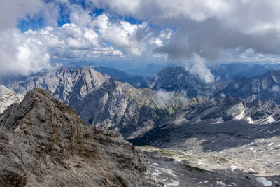 Scenic view of snowcapped mountains against cloudy sky