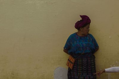 Full length of woman standing against wall