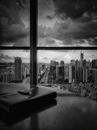 Modern cityscape against sky seen through window