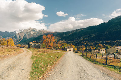 Road leading towards mountains against sky