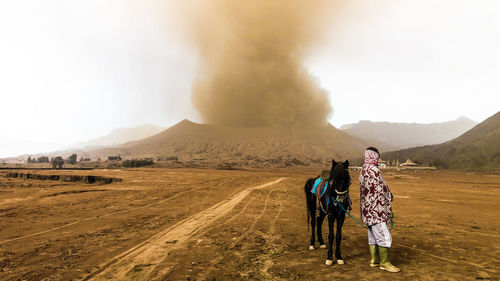 Man and horse standing at bromo-tengger-semeru national park