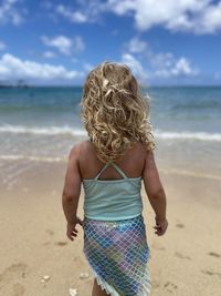 Rear view of child standing at beach in hawaii