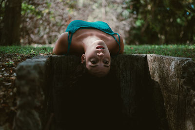 Portrait of young woman standing against trees