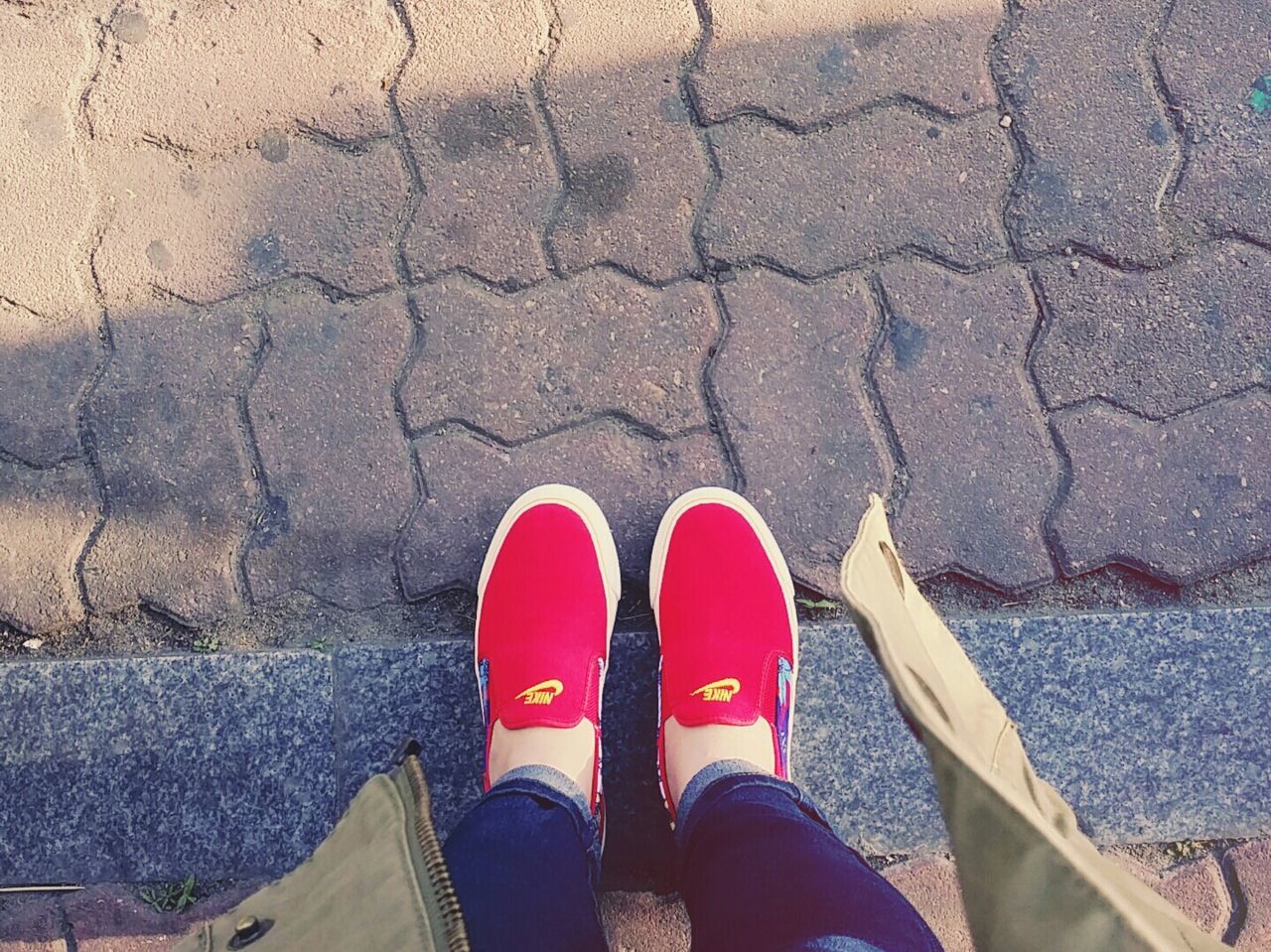 low section, person, shoe, personal perspective, human foot, footwear, standing, lifestyles, high angle view, red, directly above, pair, street, canvas shoe, jeans, leisure activity