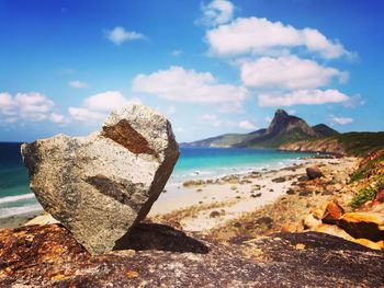 Scenic view of rocks on beach against sky