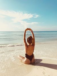 Full length of young woman at beach against sky