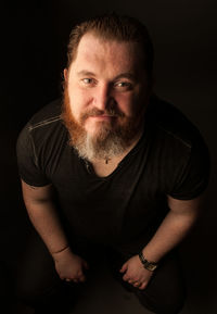 Portrait of young man against black background