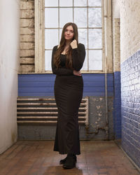 Young woman standing against wall