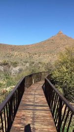 Boardwalk against clear blue sky