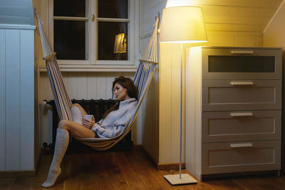 Woman relaxing on hammock at home