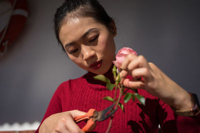 Close-up portrait of a young woman holding smart phone