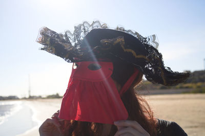 Close-up of woman wearing mask and hat against sky