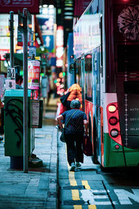 Rear view of women walking on street at night