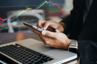 Cropped hand using calculator while sitting on table