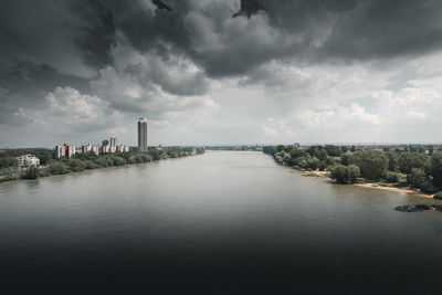 Scenic view of river by buildings against sky