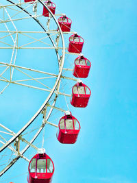 Low angle view of ferris wheel against blue sky