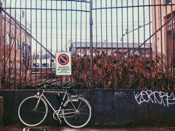 Parked bicycle against gate