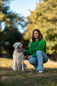 Young woman and her obedient big dog in autumn park