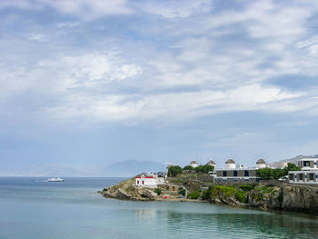 Buildings at sea shore against sky