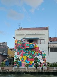 Low angle view of graffiti on building against sky