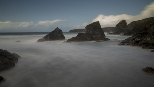 Rocks in sea against sky